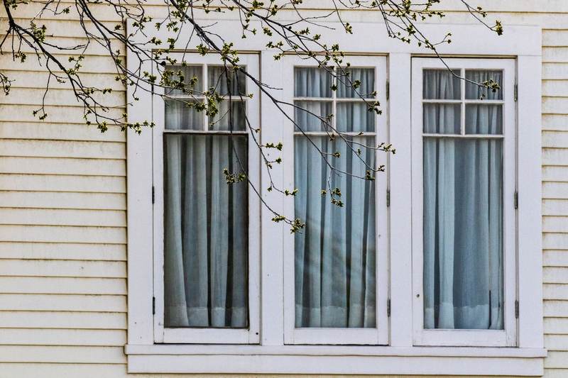 White-trimmed windows set in light horizontal lap siding