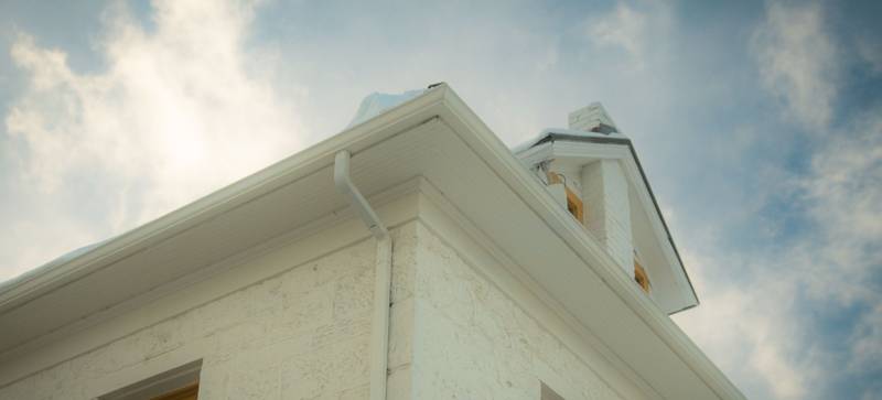 White gutter, fascia, and soffit along a roof edge, seen from below